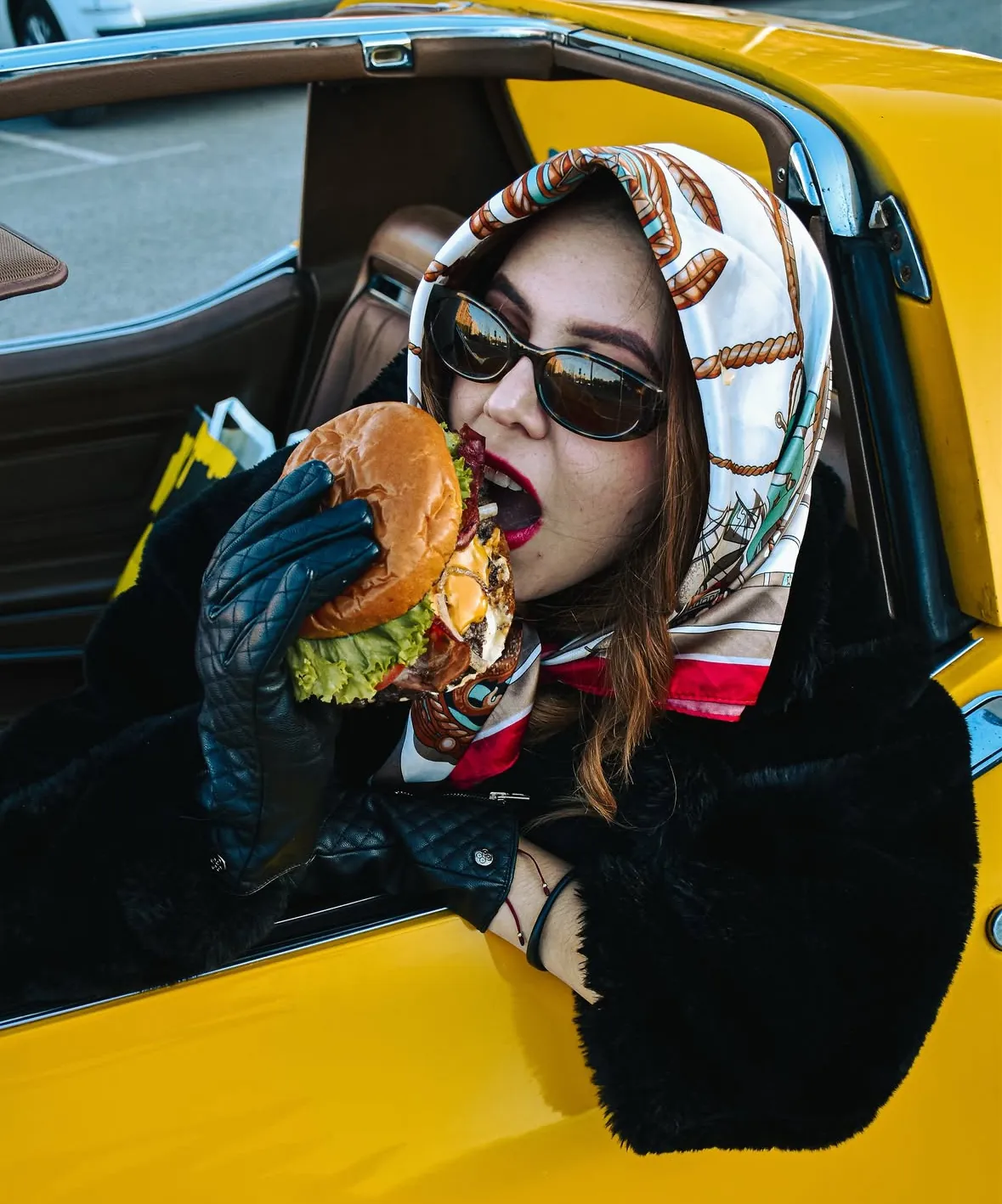 Clienta de Mr. Majo's mordiendo una burger en su coche
